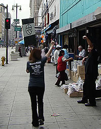 L.A. homegirl with Xcano Films walks with a unity symbol banner in the streets of downtown Los Angeles (2006)